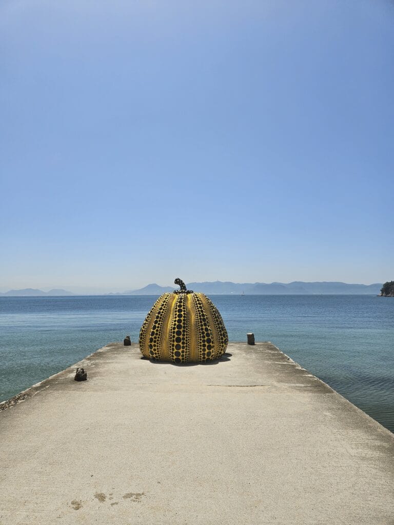 Yayoi Kusama yellow pumpkin sculpture on the pier at Naoshima Island Seto Inland Sea Japan