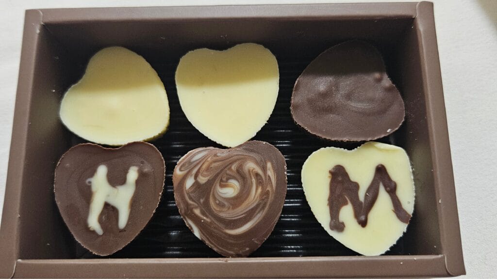 Valentine's Day in Japan: Open Valentine's Day chocolate box containing handmade chocolates decorated with the letters H and M, a personalized gift exchanged in Japan