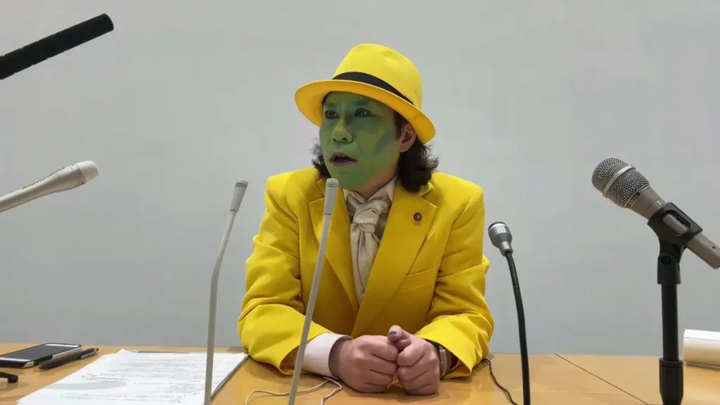 Japan's Joker, Yusuke Kawai, dressed as the Joker in a vibrant purple suit with green hair and white face paint, standing in the neon-lit streets of Tokyo. Known as the Japanese Joker, he holds a campaign sign featuring his name, symbolizing his unconventional gubernatorial run. The background captures the bustling energy of Shibuya, reinforcing his bold and theatrical presence in Japanese politics. Keywords: Joker Japanese, Joker Japan, Yusuke Kawai.
